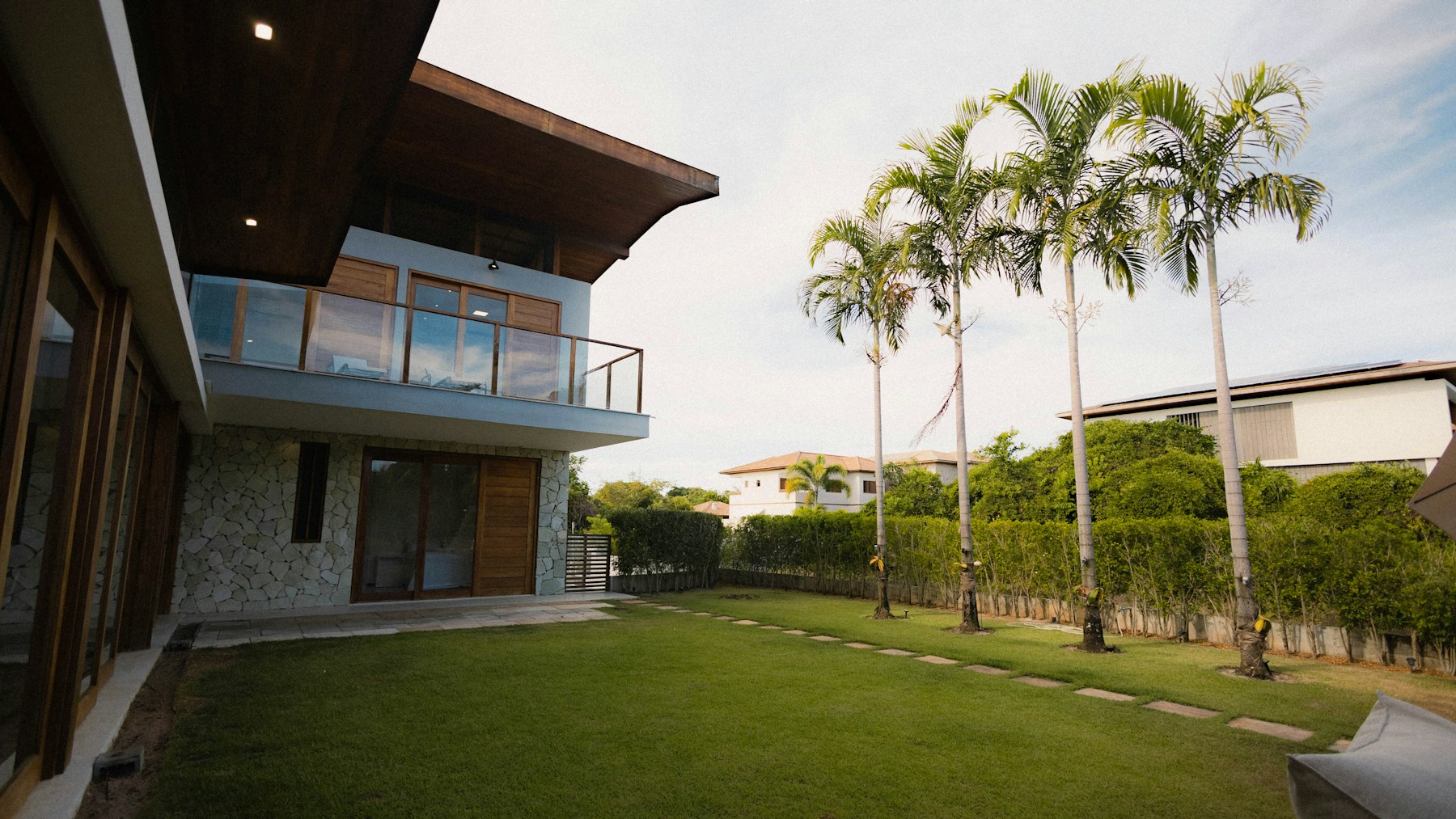 Modern tropical home with a green lawn, illustrative architecture